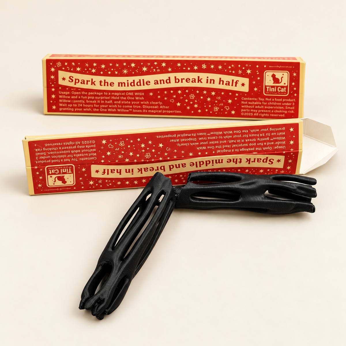 Black 3D-printed ONE WISH WILLOW toys with red and cream packaging on an ivory background
